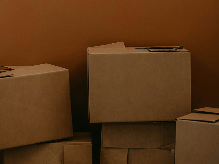 Moving boxes against a burnt orange office wall