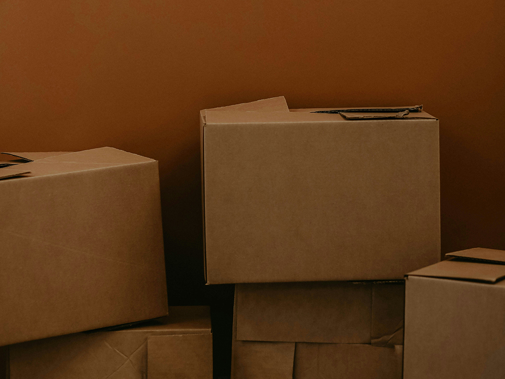 Moving boxes against a burnt orange office wall
